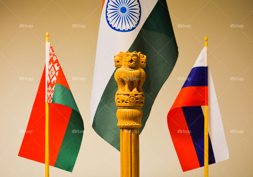 This picture displays the friendship among the three countries and one can see the National Emblem of India nicely carved on a wooden log by a carpenter which displays four lions roaring in front of the Indian flag at the centre. 
