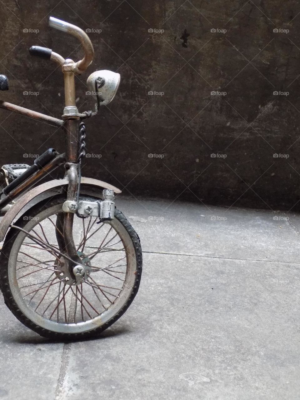 Old, rusty and broken toy bicycle