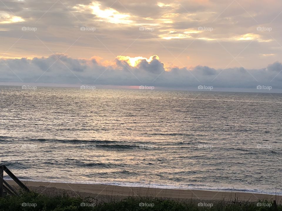 Dawn awakens over the Atlantic. A peaceful quiet morning of inspiration watching the golden glow of an ocean sunrise. Even in turbulent times, God’s grace shines through.