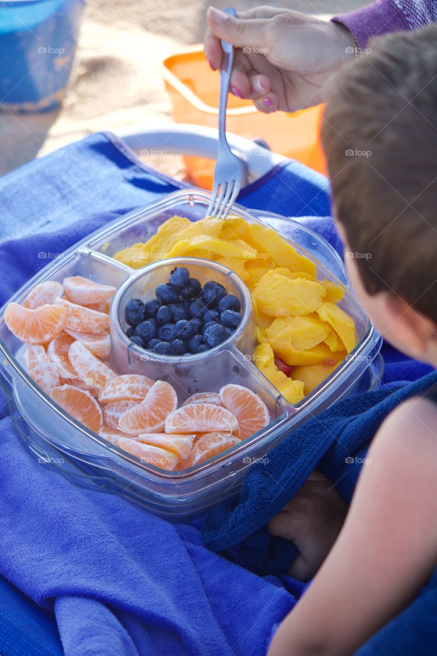 Eating assorted fruit on the beach 