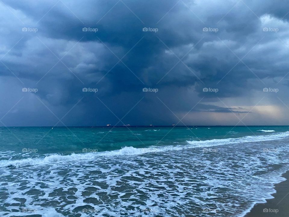 Storm clouds moving in over a beach at sunset