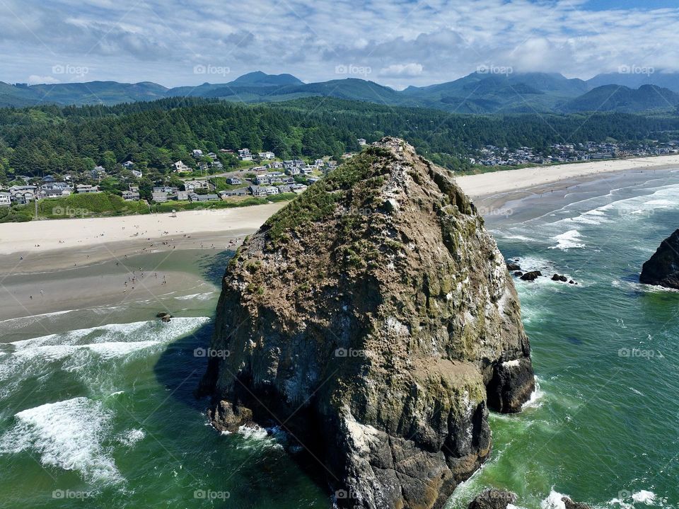 Haystack Rock standing tall amidst the serene beauty of Cannon Beach, where tide pools meet the endless horizon