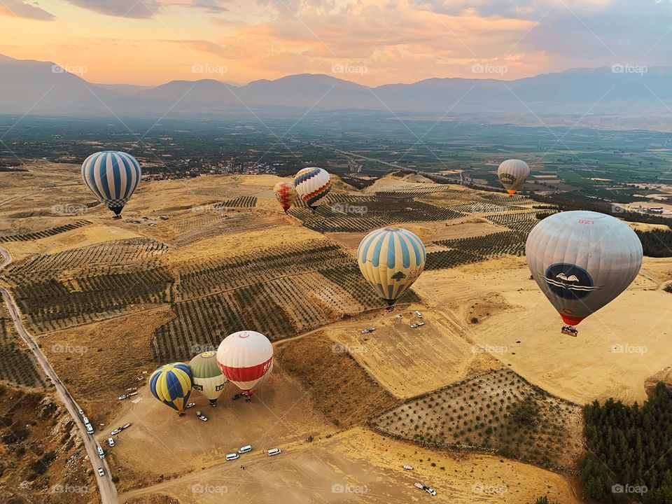 Hot air balloons flying over the beautiful landscape with open road 