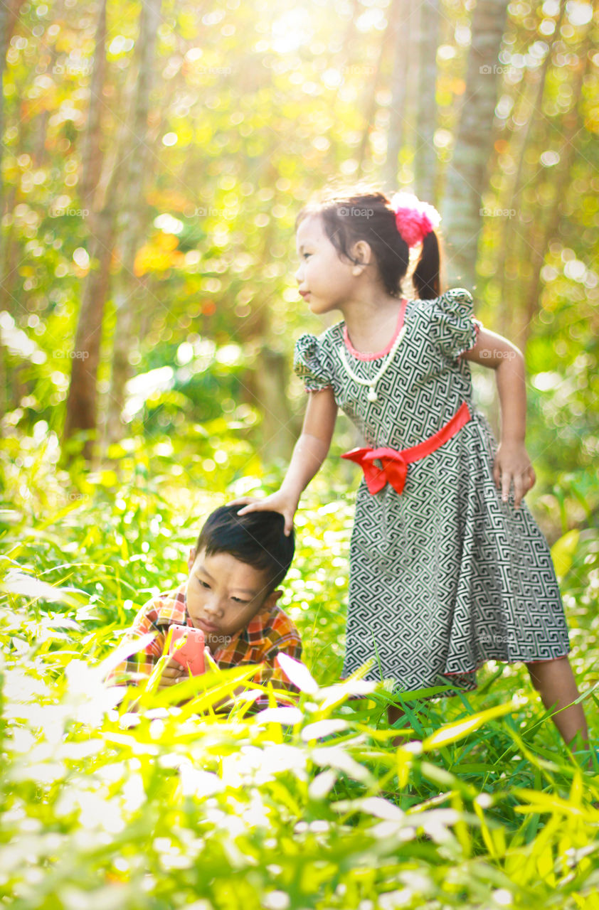 Asian boy with her sister using mobile phone