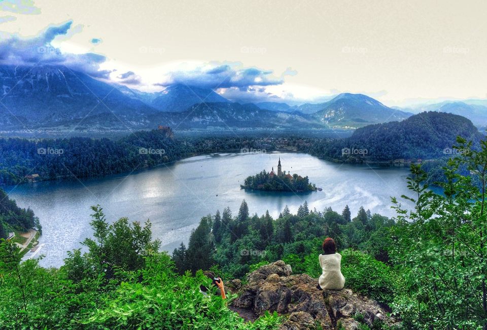 Perfect moment . Beautiful view of unidentified young woman enjoying the amazing view of lake Bled peacefully.  