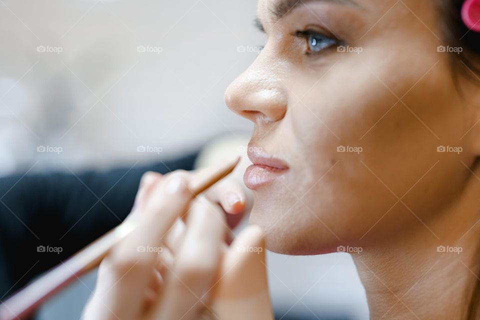 Makeup artist applies makeup to a woman.  Work in a beauty salon.  Professional cosmetics