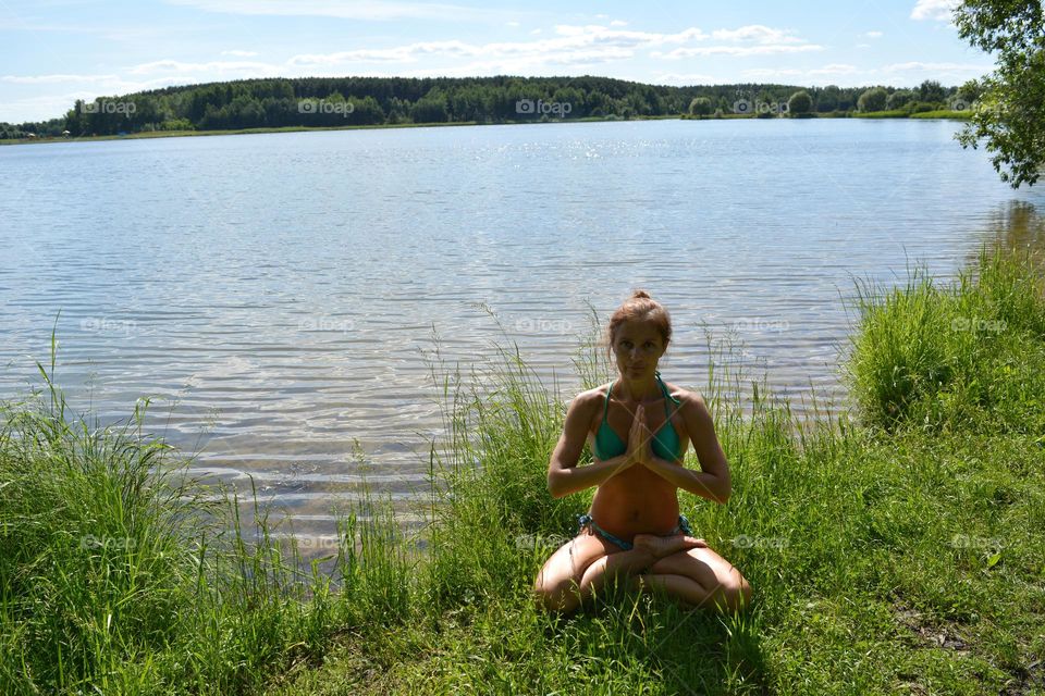 woman meditation on a lake shore