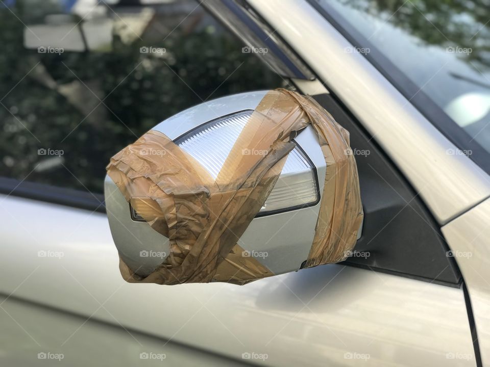Close up of Broken Side View Car Mirror with Repair by Plastic Tape
