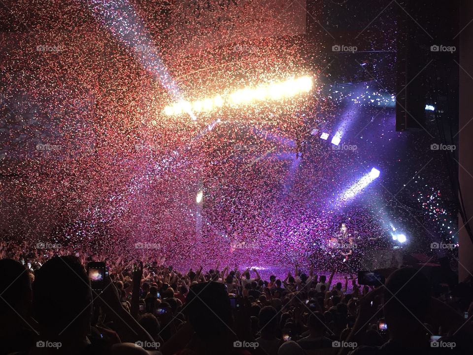 Celebration at a concert and all the confetti coming down over the crowd. 