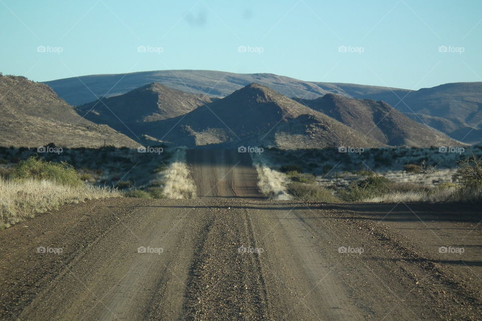 Taking a long road trip on a lonely gravel Road, the beautiful scene makes you feel free and young at heart again!