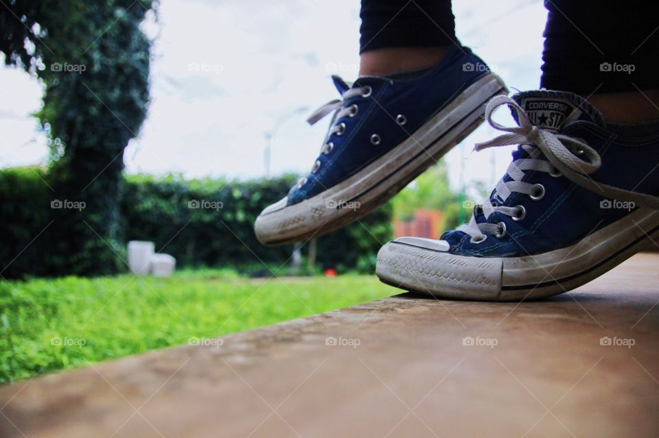Converse sneakers in blue active shot in the nature.