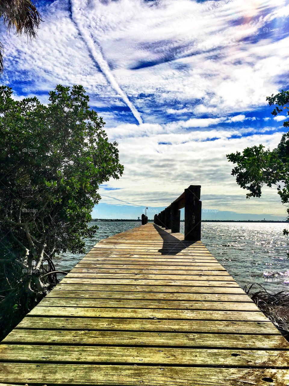 Boardwalk against cloudy sky