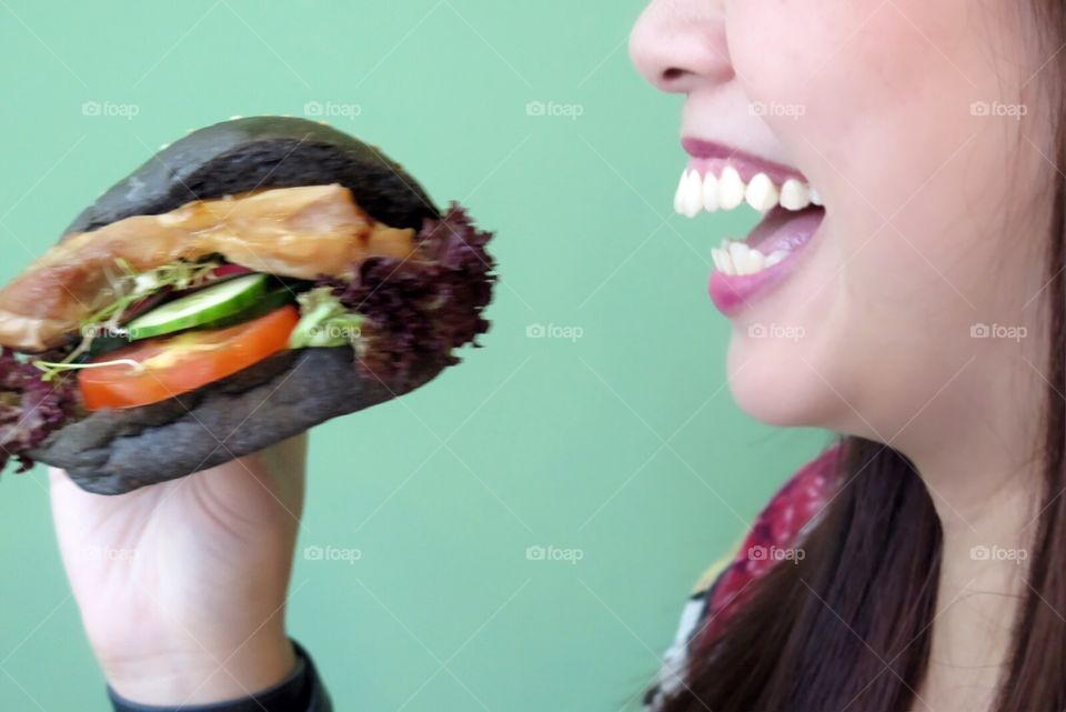 Girl holding burger and laughing 
