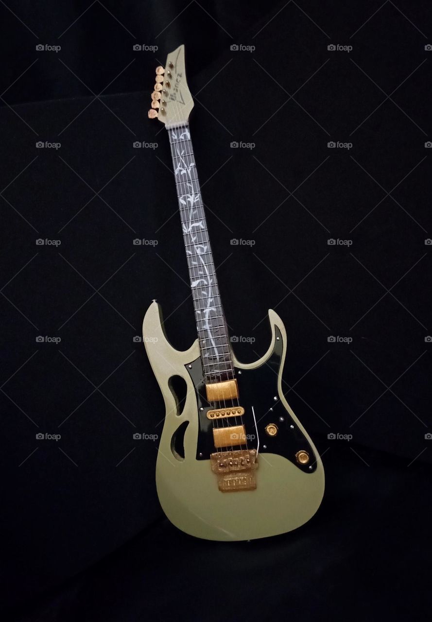 Miniature guitar in black background