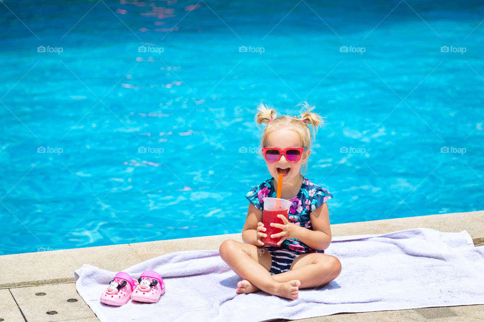 Cute little girl with blonde hair in swimming pool 