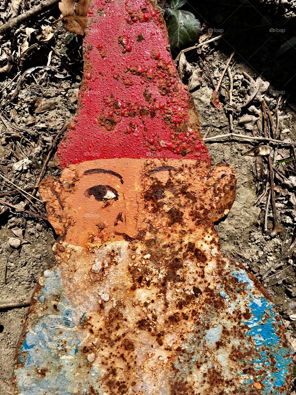 abandoned and rusted metal garden gnome