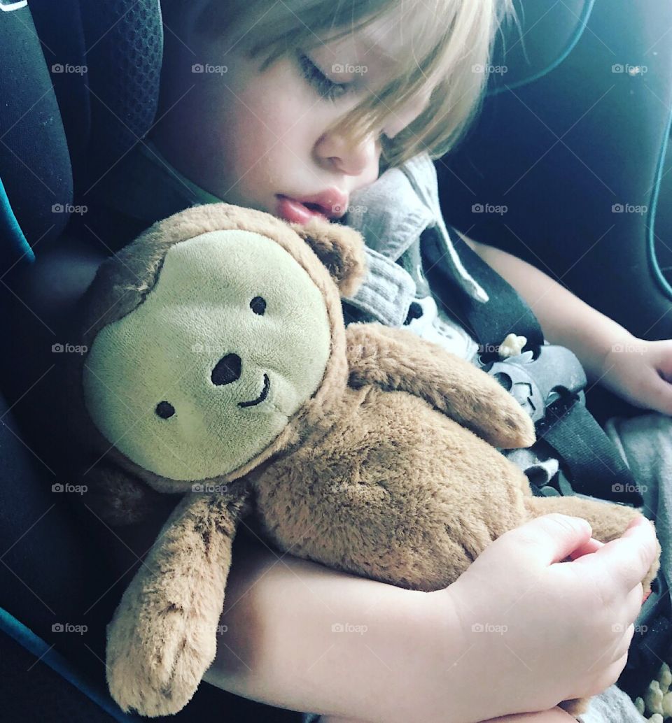 A child sleeping while grasping its best friend 