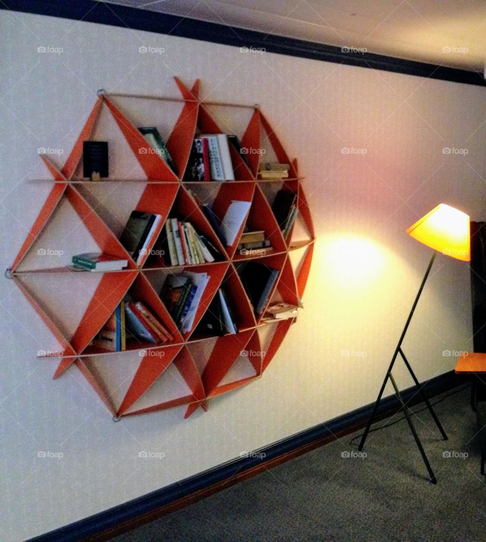 Futuristic triangle shaped bookshelf and floor lamp leg