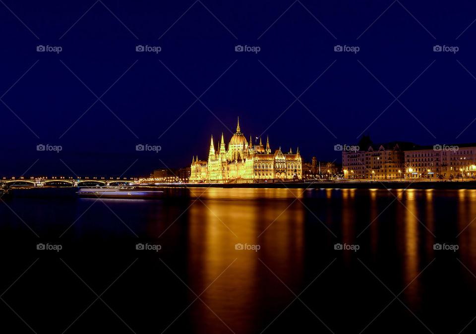 Budapest parliament by Danube river at night