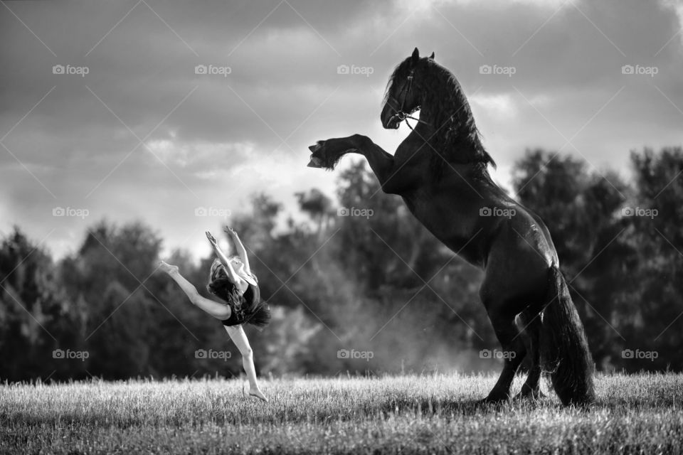 Little gymnastic girl with black stallion 