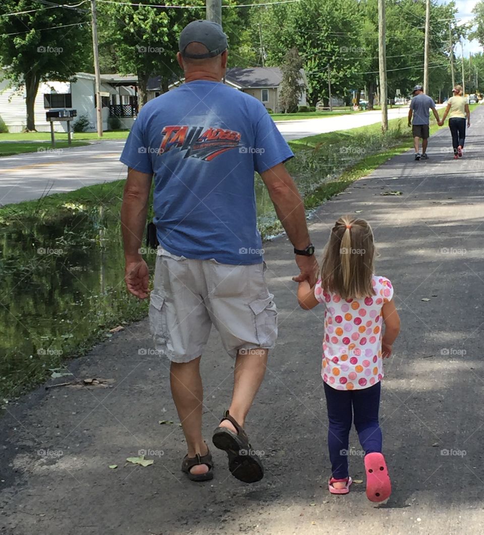 Walkin With Papa. Papa and his granddaughter are catching up to Mom & Dad up ahead