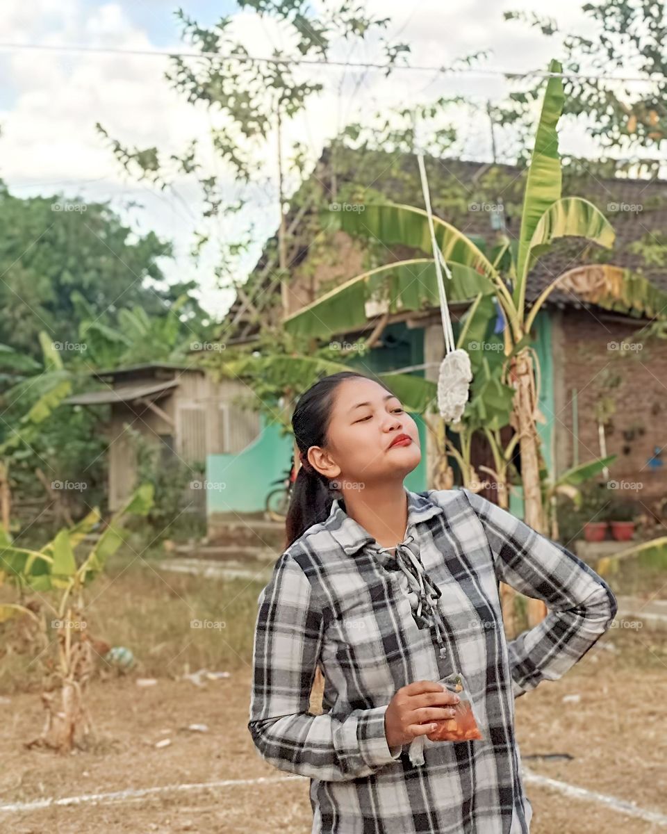 Portrait of a young mother trying to eat crackers hanging on Indonesian independence day