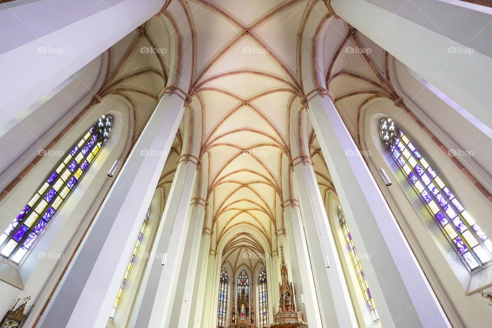 Looking up on beautiful pillars, ceiling and windows indoors, church architecture 