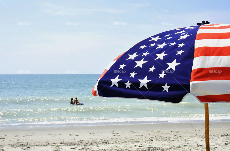 A patriotic umbrella at the seashore.