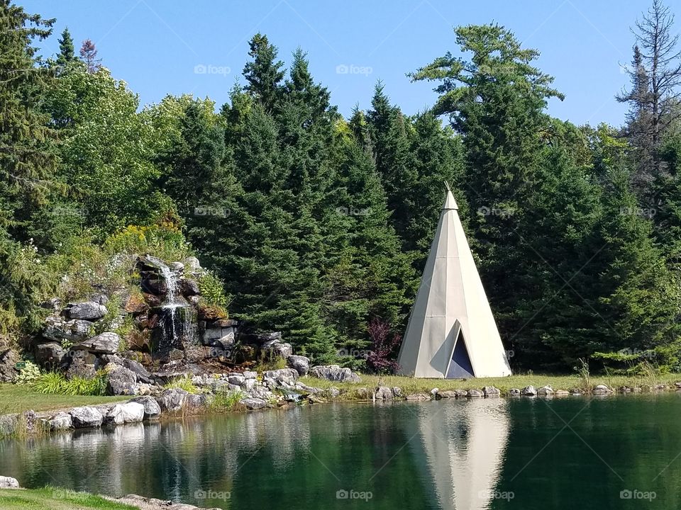 Pond with waterfall and teepee