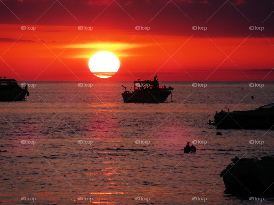 Sun with boats from the beach.  (Praia - Italy ).