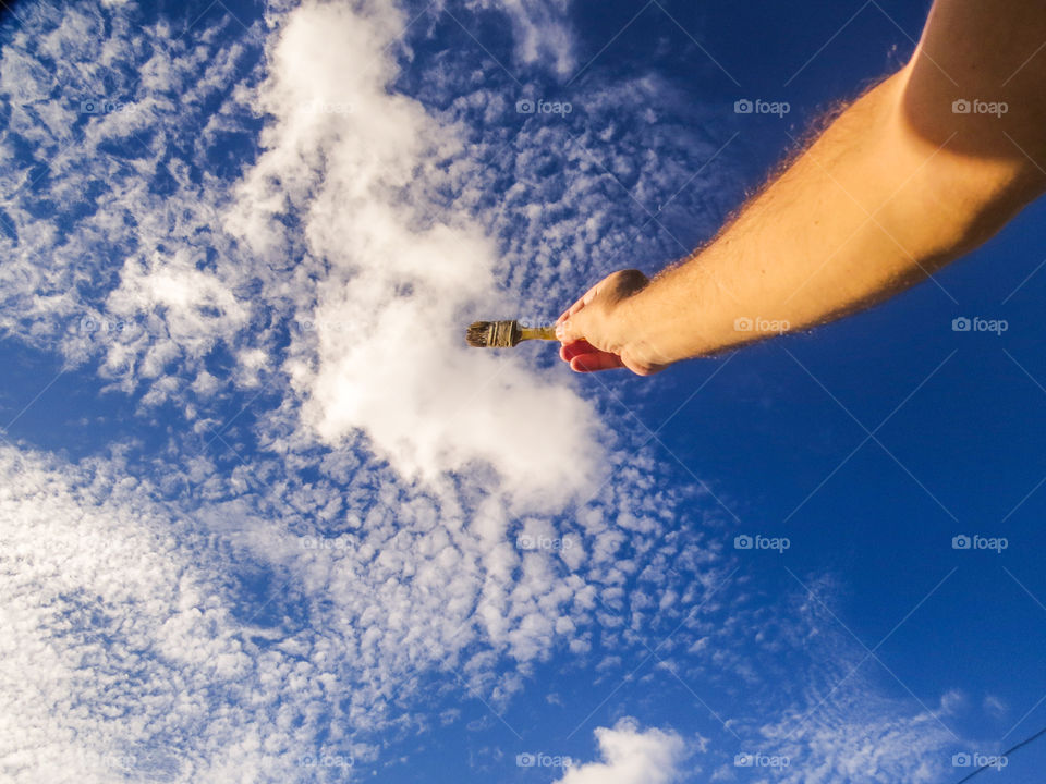 human hand painting the sky perspective.