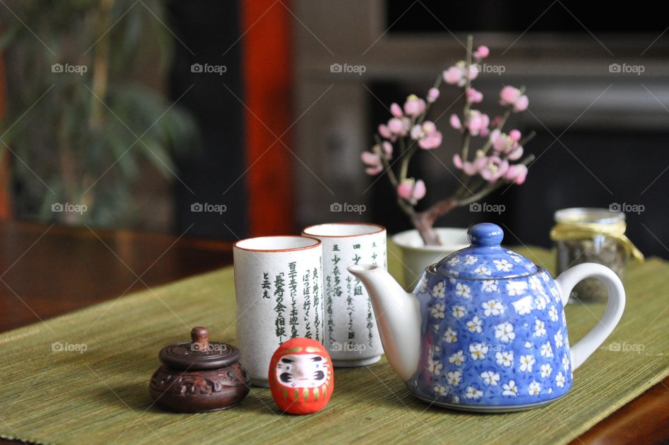 Porcelain tea set with vase on table