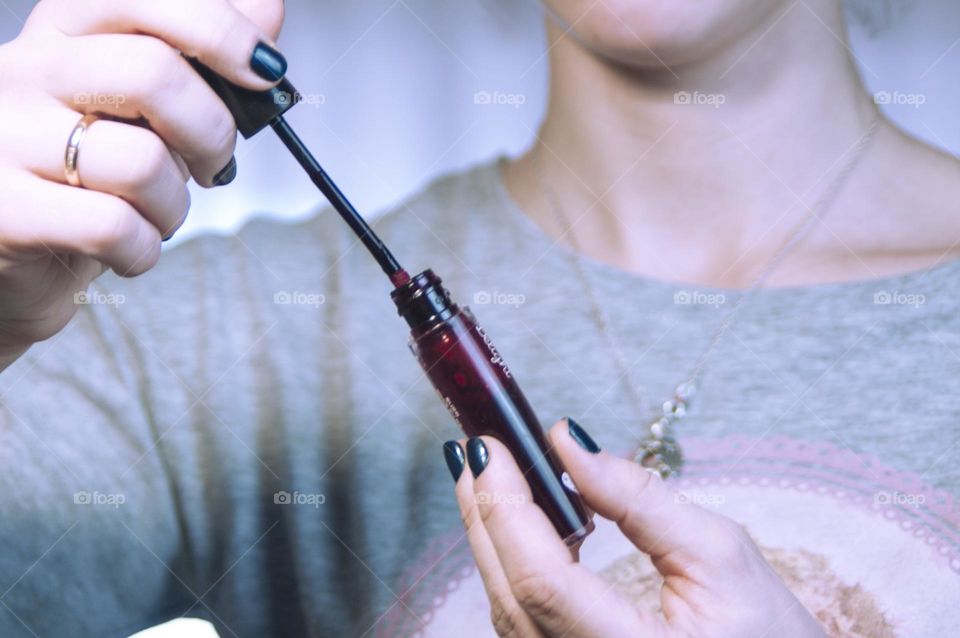 woman paints her eyes with mascara