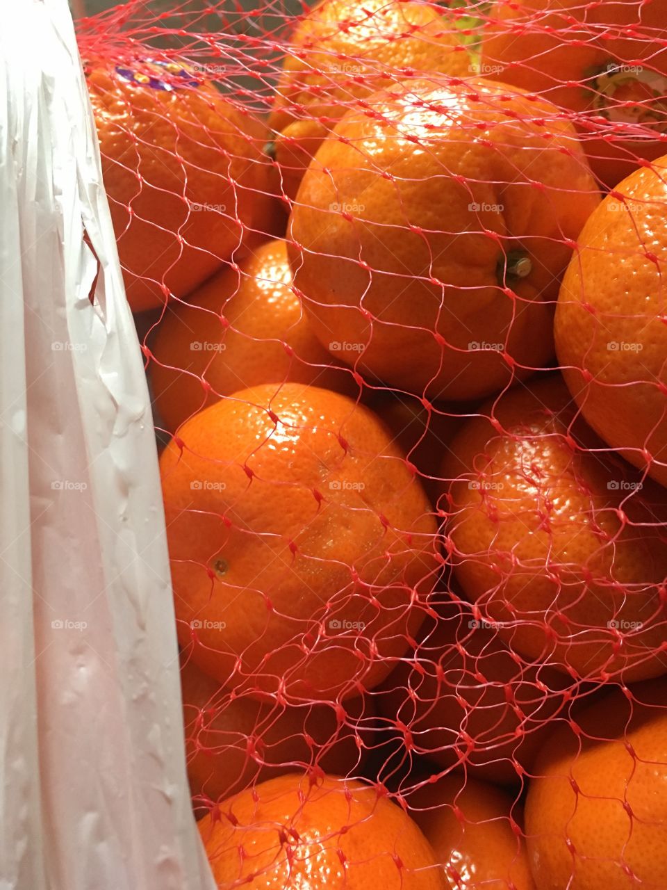 Oranges in netting compared my home from a shopping trip.  