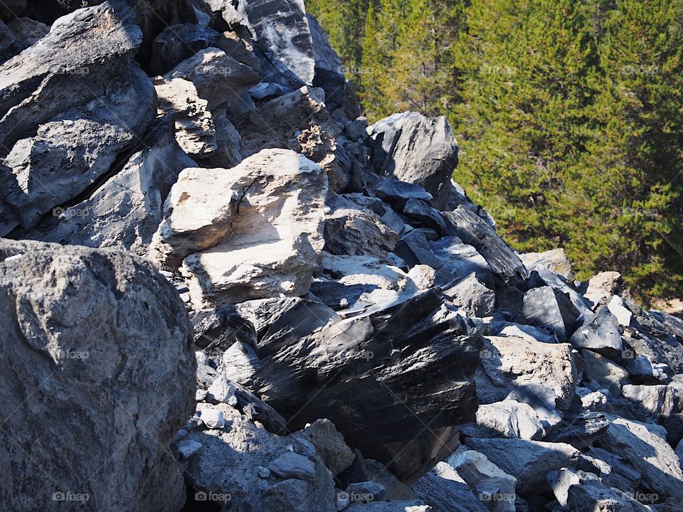 Textured Obsidian and hardened lava rock on a sunny fall day at the Big Obsidian Flow in the Newberry National Volcanic Monument in Central Oregon. 