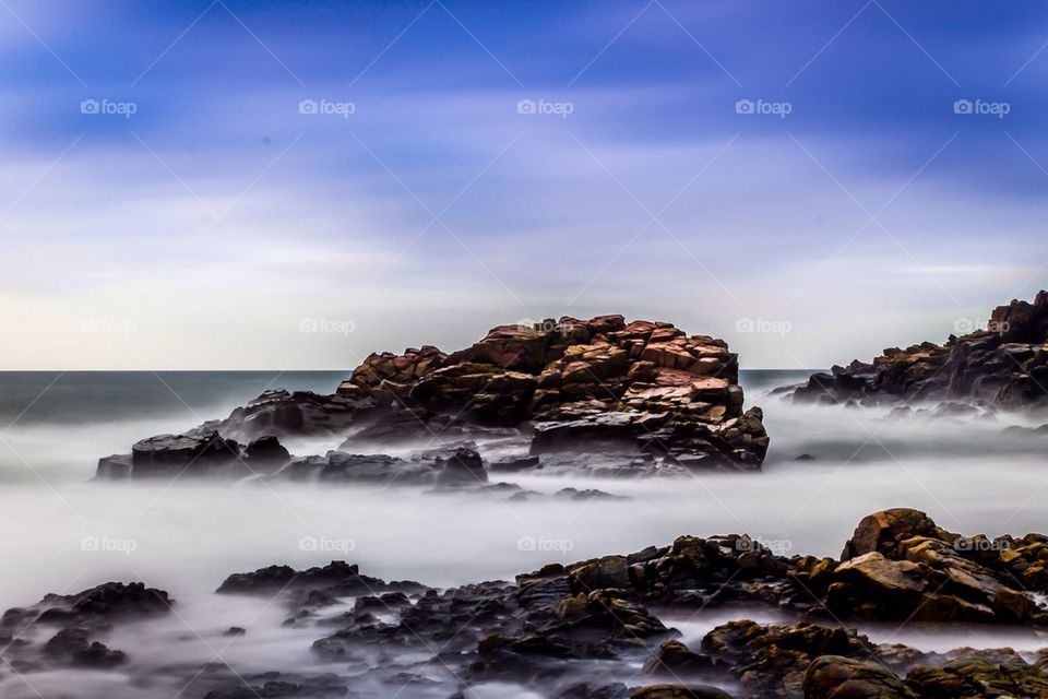 View of rock in sea during foggy weather