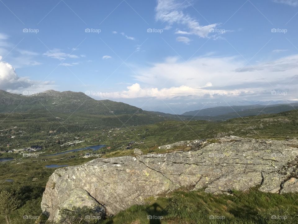 The beautiful mountains and nature in Norway, in the sunny summer weather. The grey rocks, white clouds and small lakes in the background makes up for a great view.