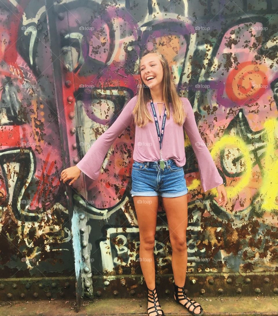 Beautiful teenage girl standing near the graffiti wall