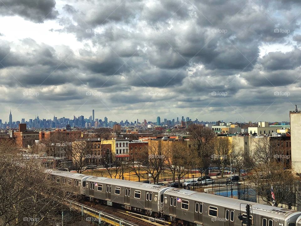 NYC skyline in the distance, train in the foreground 
