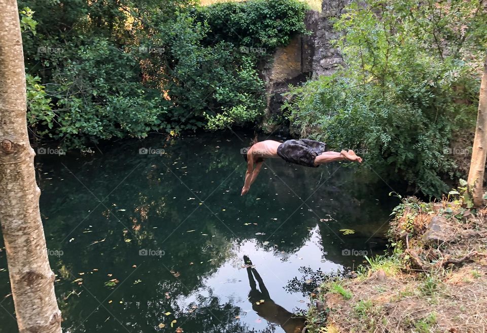 A man dives into a natural swimming hole