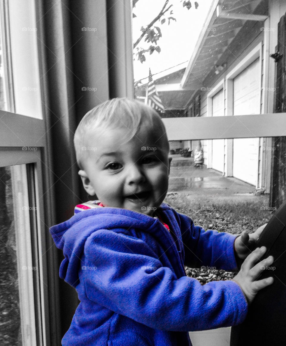 Young little girl having fun in her bright blue jacket. It adds pop to a black and white world. 