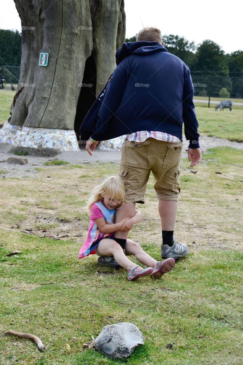 Young girl clinging to her fathers leg at Knutenborg Zoo in Denmark.