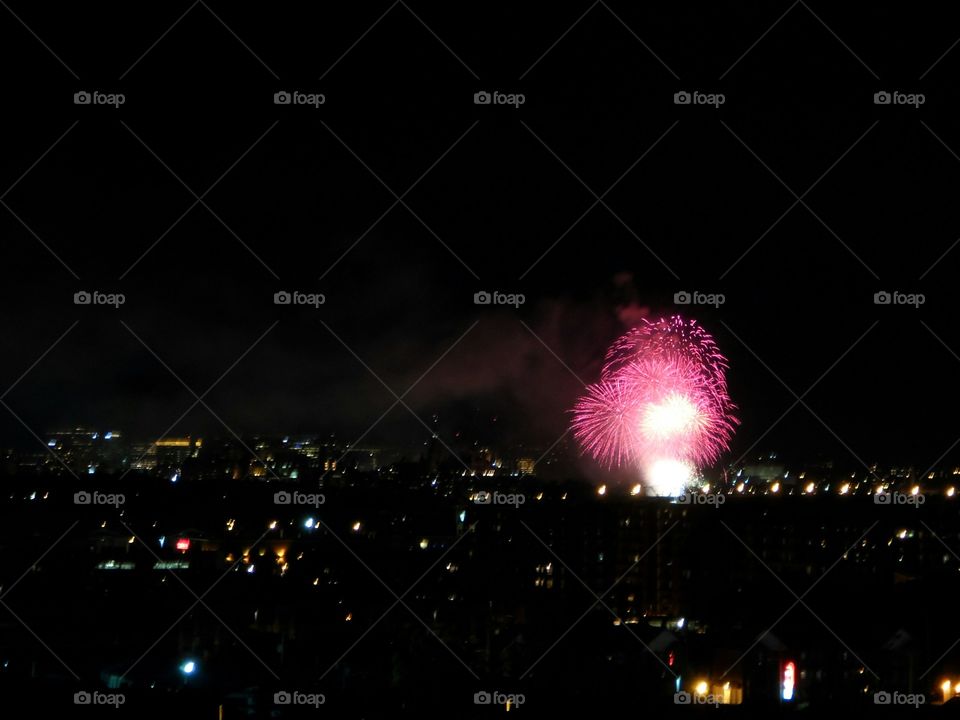Pink fireworks over city. nice spray of pink fireworks over city