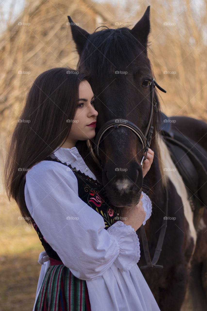 Woman hugging horse at farm