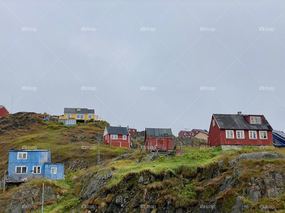 Brightly painted houses on a hill in a small town in Greenland 