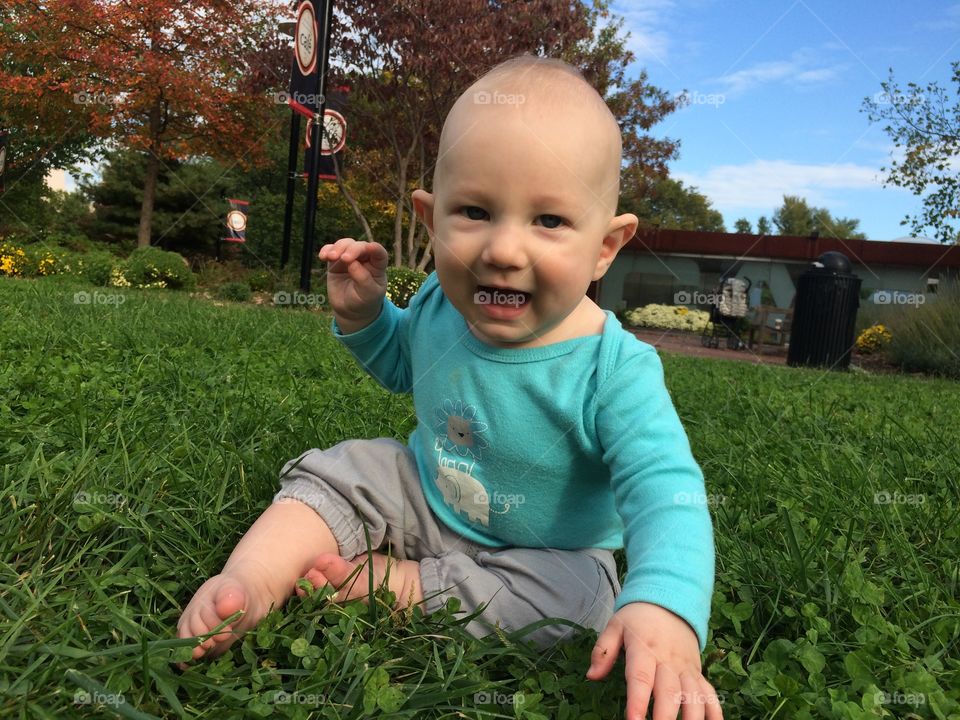 Baby boy 6 m old playing on the lawn 