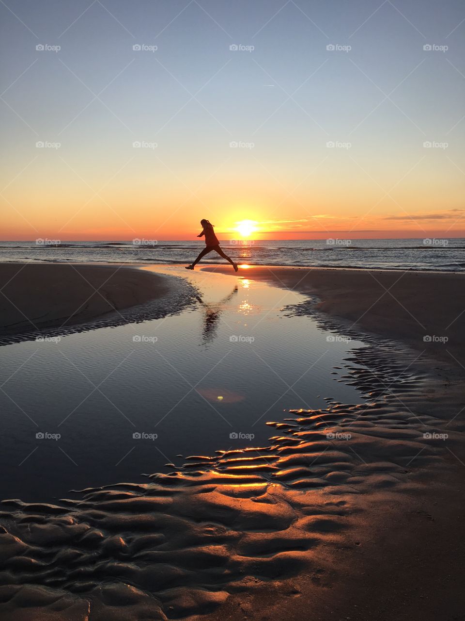 Girl jumping at the ocean 
