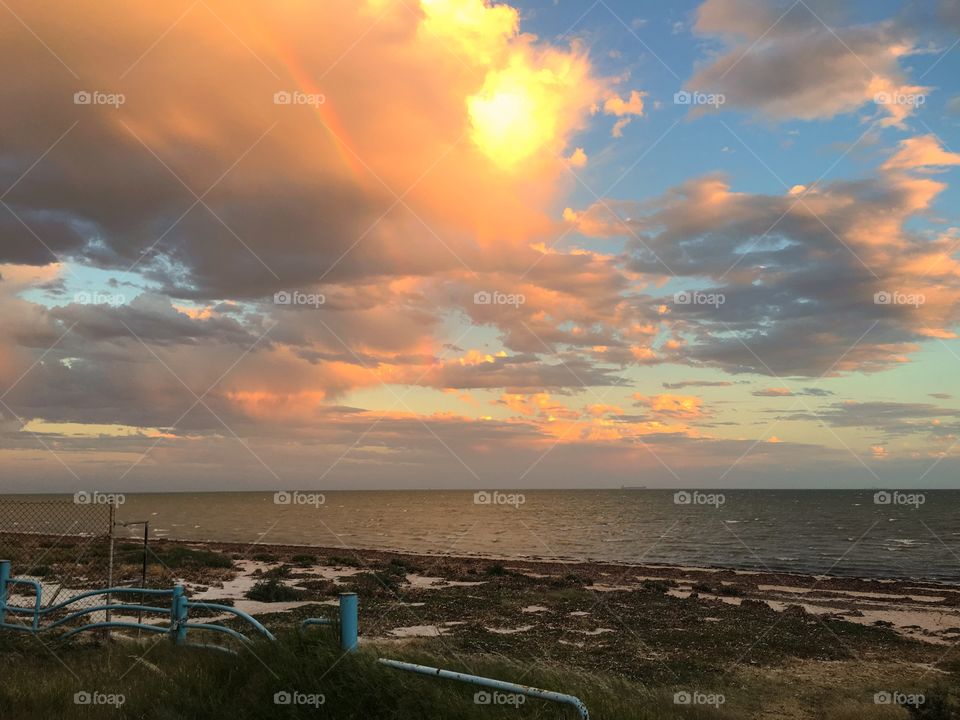 Rainbow through a storm cloud at sunset 