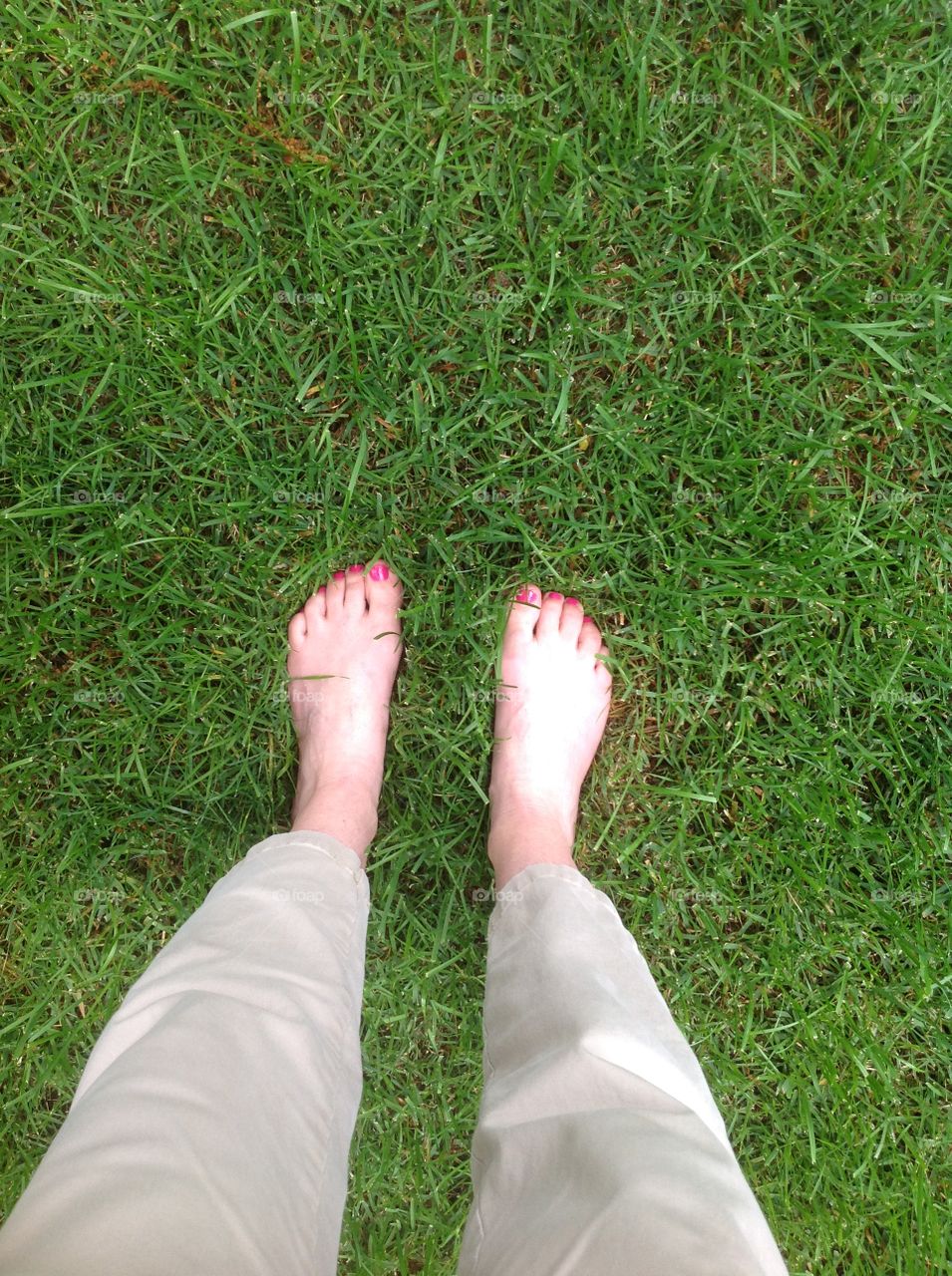 Feet in the green grass.