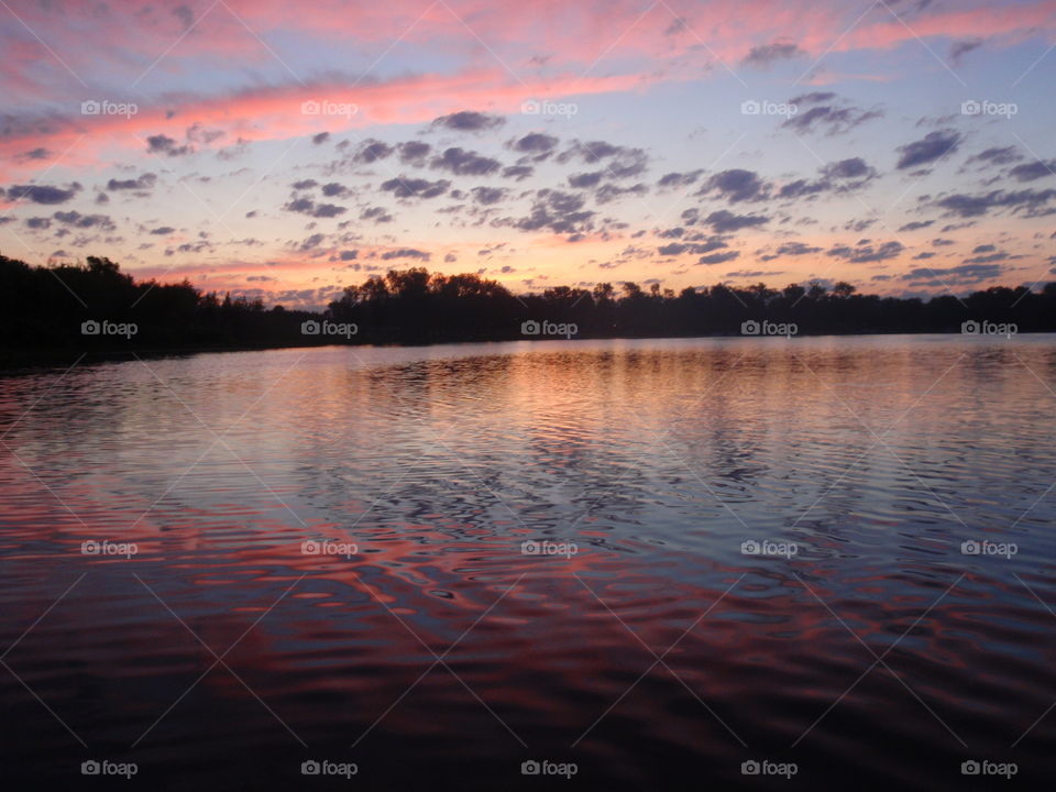 Pink water. Sunrise reflecting on surface of inland lake